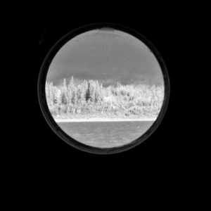 A glimpse through a circular portal of water and boreal forest