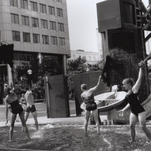 black & white photo: 5 dancers in swimsuits in a fountain